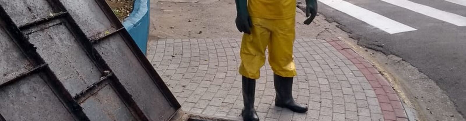 Técnico realizando limpeza de caixa de inspeção